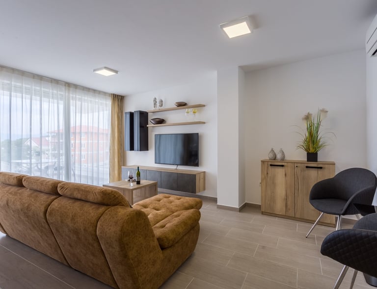 Wohnzimmer mit gemütlichem Sofa und TV im Ferienapartment in Malinska
