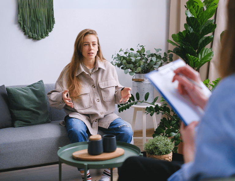 A woman sitting on a couch for a behavioral health consultation