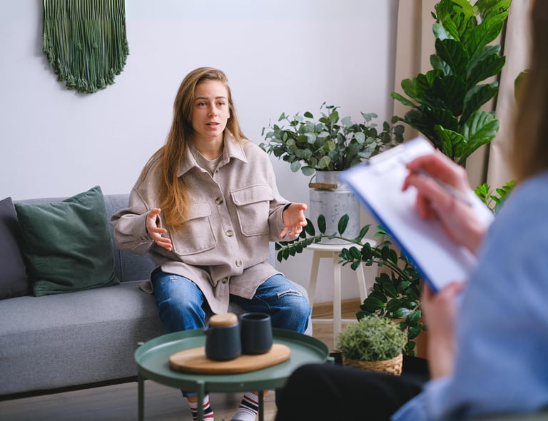 A woman sitting on a couch for a behavioral health consultation