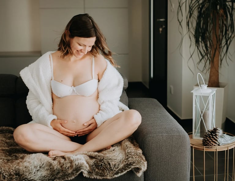une femme enceinte assise sur son canapé 