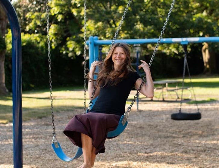 Tina Lilly, MS, LPC at play on a swing set
