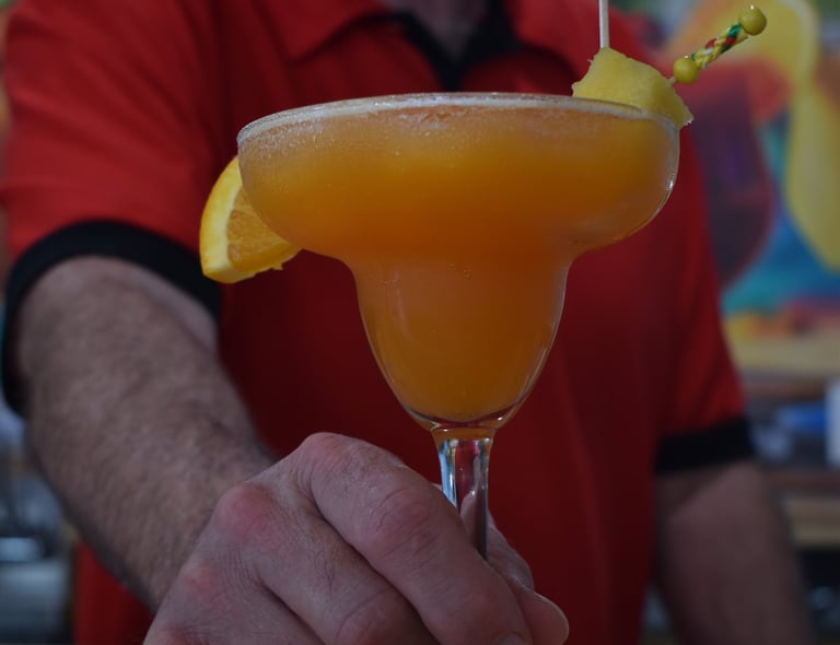Picture of man serving orange tropical drink