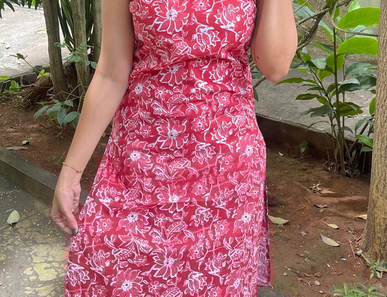 a woman in a red dress with a cat on her head