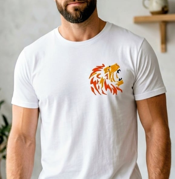 Bearded man wearing a white t-shirt featuring an orange embroidered lion head logo.
