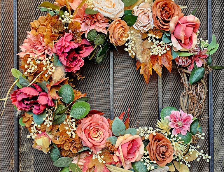 Luxury permanent botanical autumn wreath with terracotta roses, peonies, and fall foliage on a grapevine frame