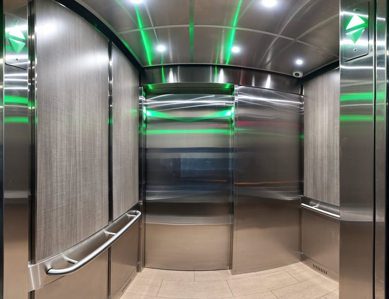 elevator interior, stainless steel on ceiling and front wall, light wood panel walls and tile floor
