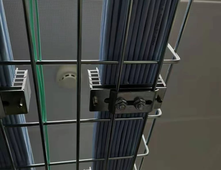 un chemin de câbles en treillis métallique avec plusieurs fils et un dispositif de fixation de câble