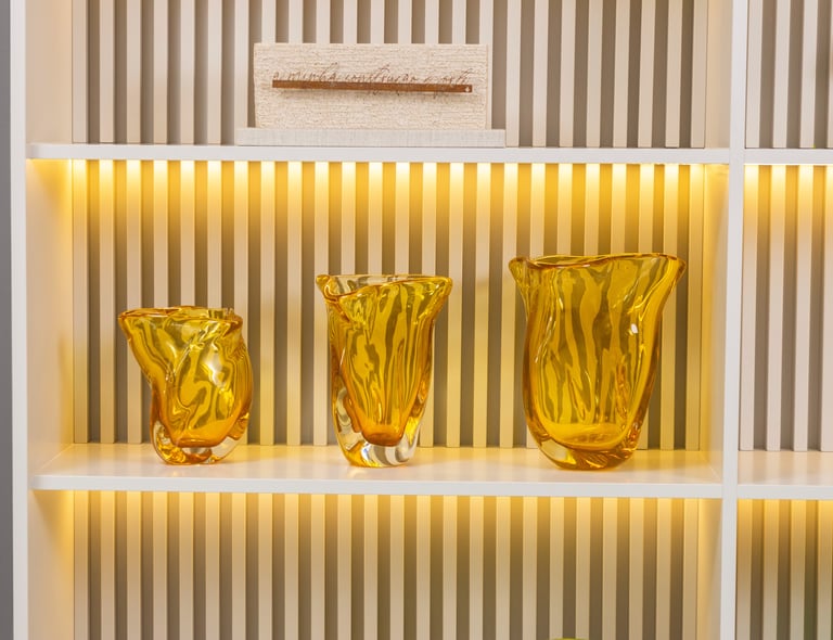 a shelf with three vases and a plant in the middle
