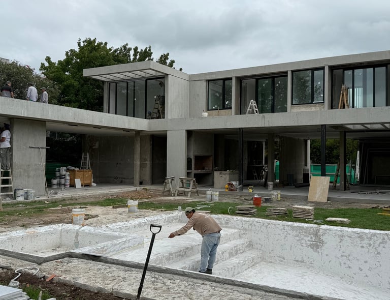 a man standing in front of a house with a shovel