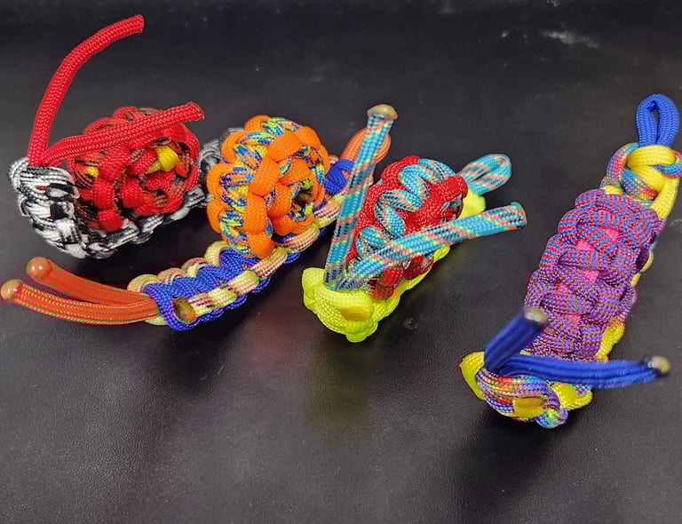 Four colorful paracord snails lined up next to each other