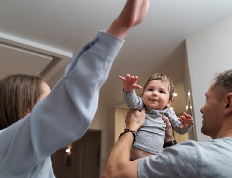 a man and woman holding a baby in a living room