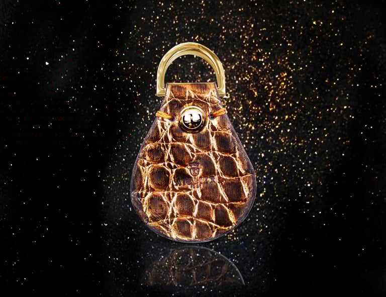 Luxurious genuine brown alligator leather key holder on a sparkly black background, reflecting elegance and craftsmanship.
