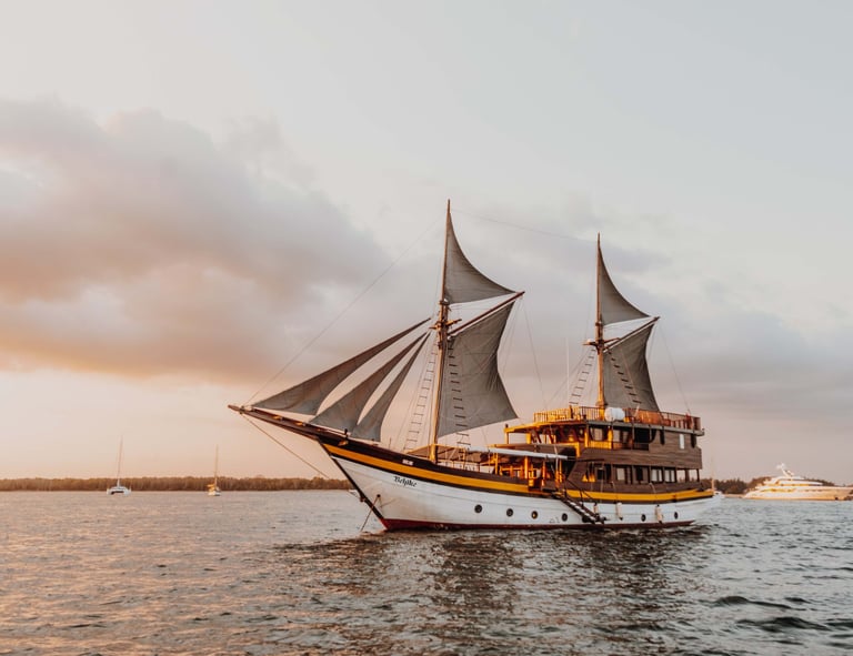 a boat with sails is sailing on the water