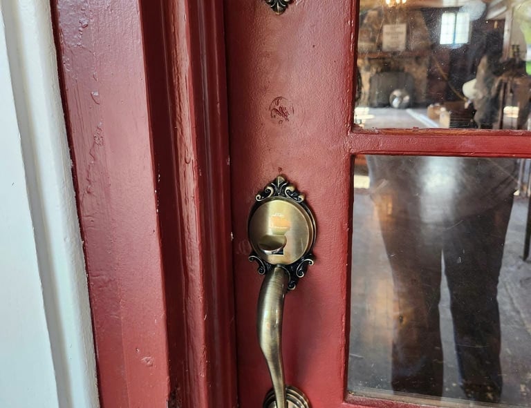 Red residential front door with brass deadbolt and handle lockset