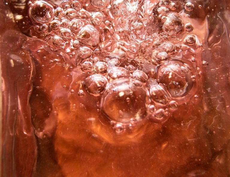 Un zoom a un té de kombucha, se aprecia burbujeante por sus levaduras.