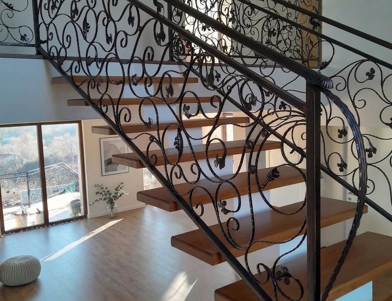 Modern floating wood staircase featuring custom ornate wrought iron railings and banisters.