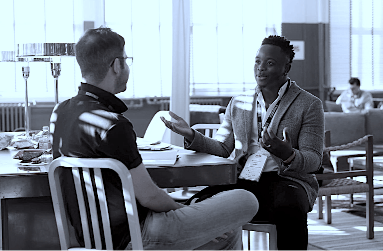 Two business professionals having a collaborative meeting in a modern open office workspace.