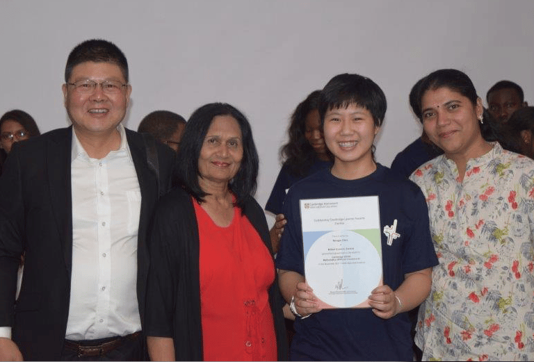 a group of people standing around a man holding a certificate