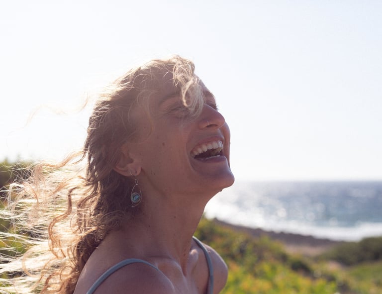 a woman with blonde hair and a blue dress smiling