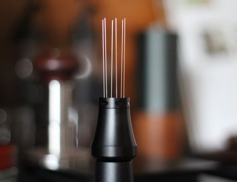 Black espresso WDT tool with stainless steel needles for coffee distribution and declumping.