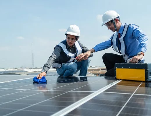 Dos hombres con casco de protección en color blanco examinando el lugar donde se hará la instalación