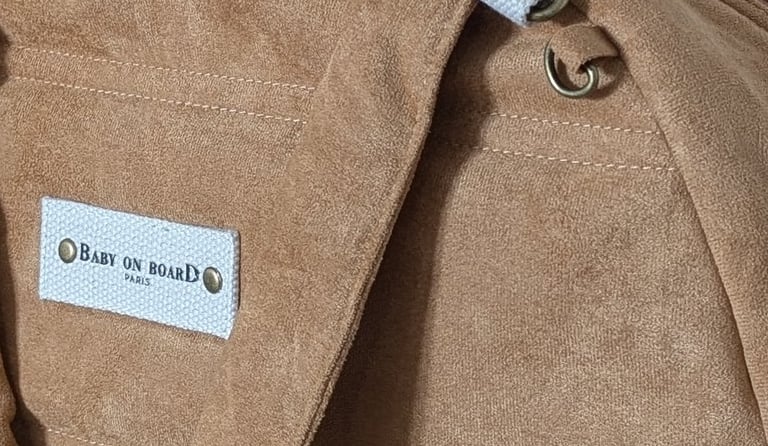 Un sac à langer de couleur camel, conçu dans une matière suédine.