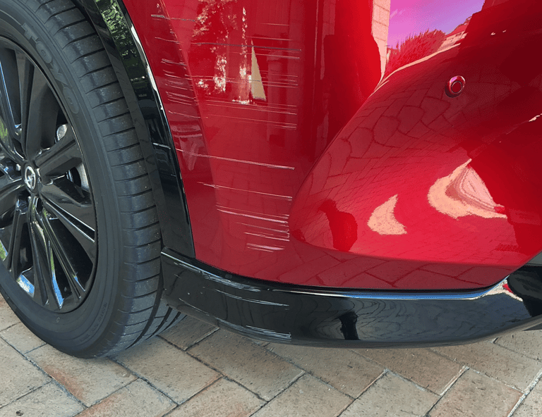 Scratches and paint damage on the front bumper of a red Mazda before scratch repair Perth