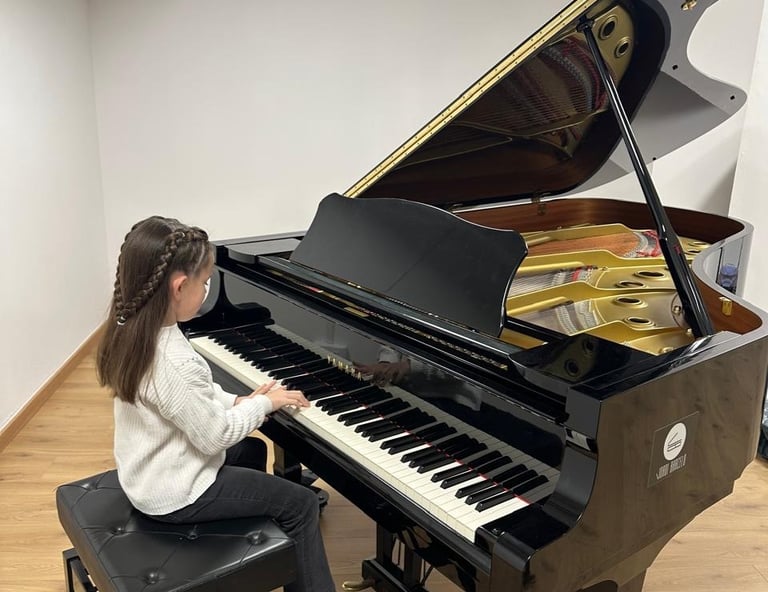 a young girl playing a baby grand piano in a music school
