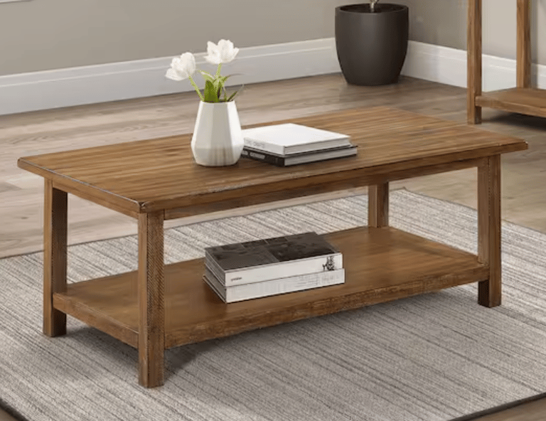 Rustic brown solid wood coffee table with storage shelf on a grey area rug.