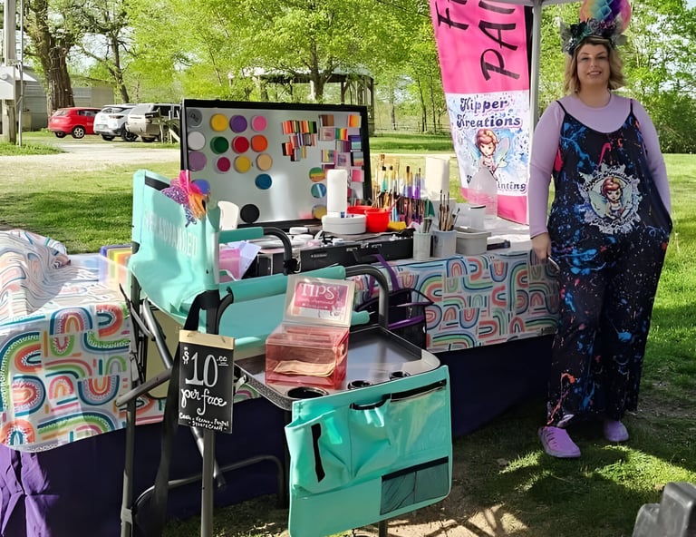 Sarah Kipper standing in front of her service table, "face painting" sign in the back