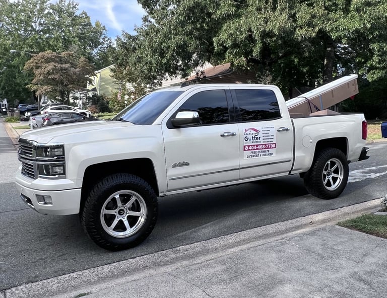 Company truck loaded with gutter materials and installation equipment.