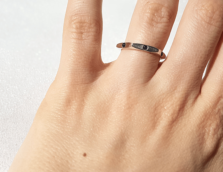 Elegant sterling silver ring with small blue sapphire gemstones, handcrafted for women, showcasing a minimalist design on a