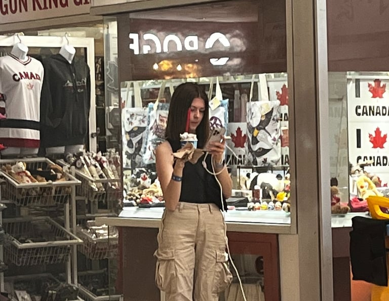 Girl looking at phone while holding ice cream