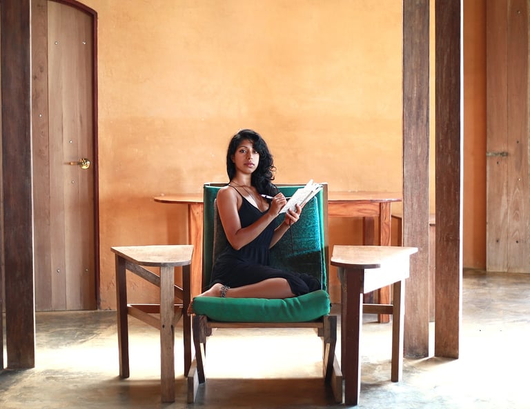 Jungle Flower sitting in a comfy custom built wooden chair, writing stories and poetry.