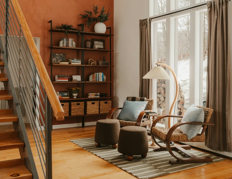Warm modern living room with staircase, wooden shelving, and lounge seating