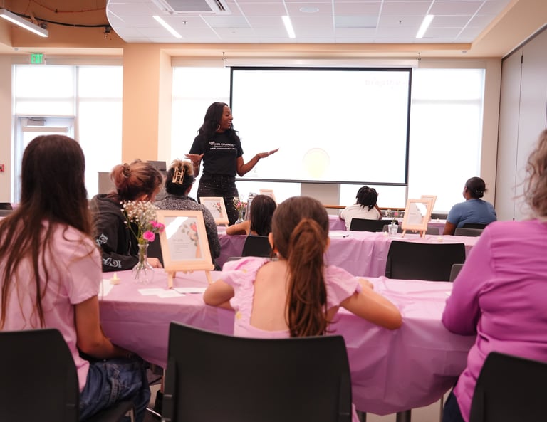 Ain leads an empowering workshop for women and girls at a community center event.