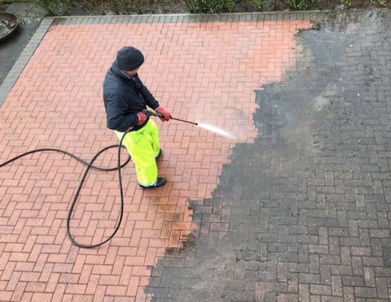 a man in yellow raincoats is using a pressurer