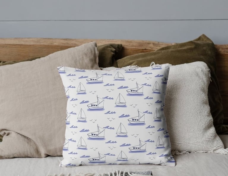 a bed with a pillow and sailboat pattern on pillow