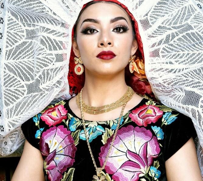 mujer vistiendo traje típico y utilizando joyería artesanal