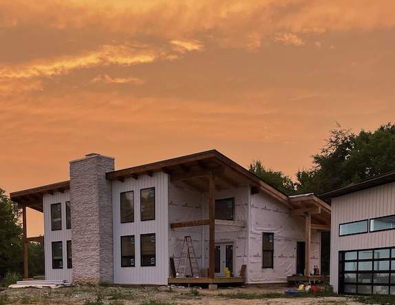 white timberframe home at sunset