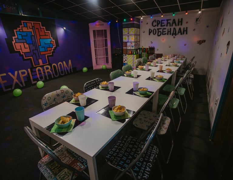 Svečano postavljen sto u party room-u igraonice Exploroom Niš, spreman za proslavu dečijeg rođendana ispod neonskog znaka "Sr