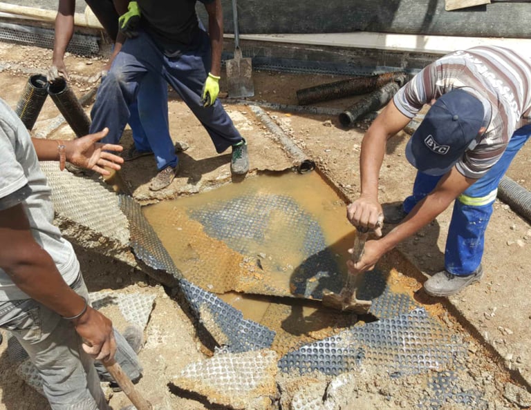 Engineers inspecting damaged concrete slab for water ingress