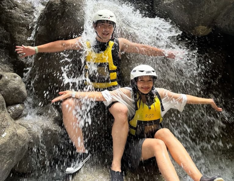 a man and woman sitting on a waterfall in a river
