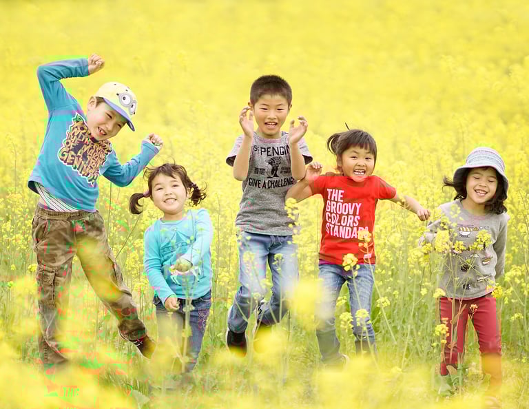 5 kids jumping in the yellow field