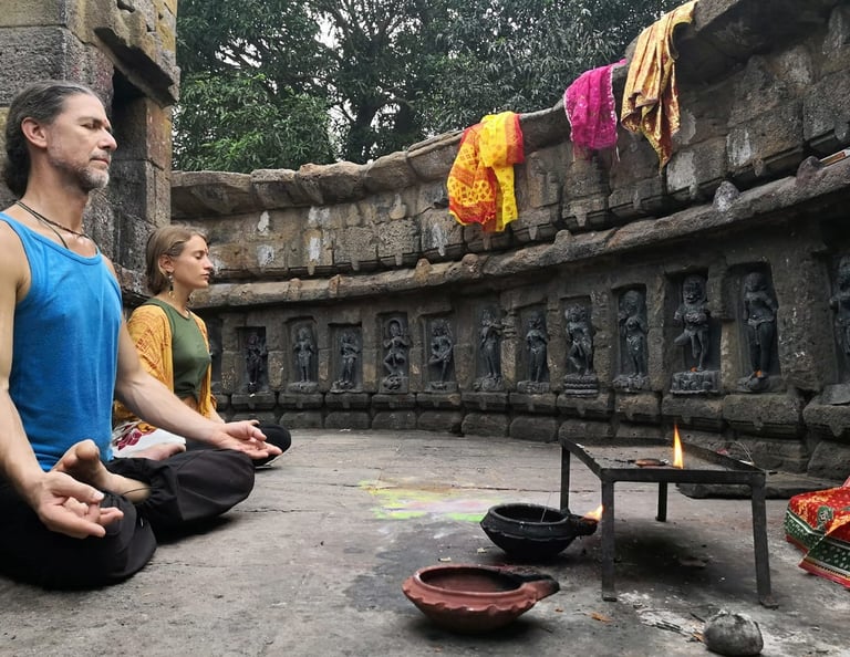 a man and woman sitting in meditation in India's temple