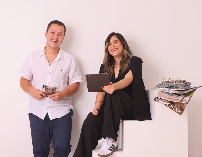 a man and woman sitting on a white cube