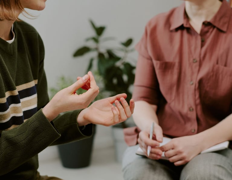 A warm, softly lit therapy room with two people facing each other