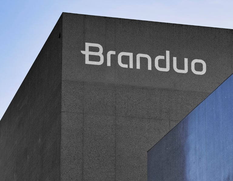 Fachada do Estúdio Criativo Branduo, com textura de cimento cinza escuro e letreiro em branco.