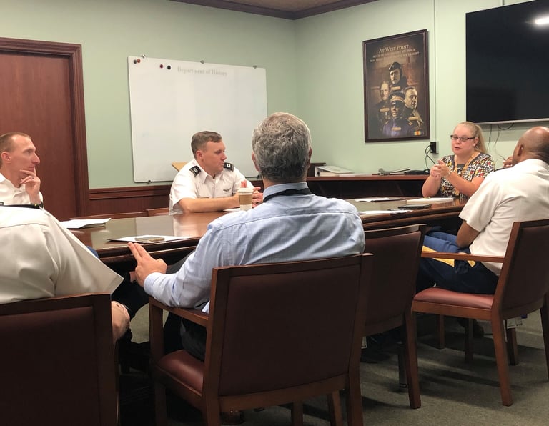 Dr. Hooton sitting at a table leading a discussion with instructors about presentation strategies