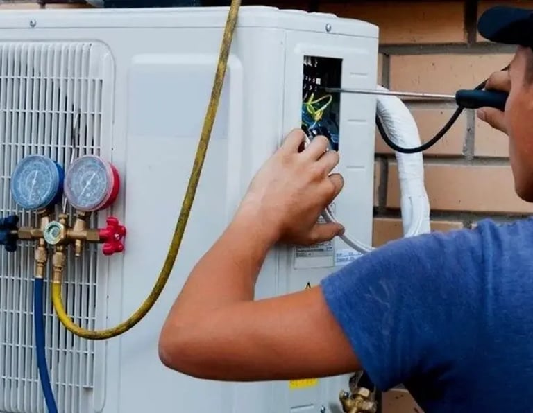 a man in a blue shirt is looking at a white air conditioner